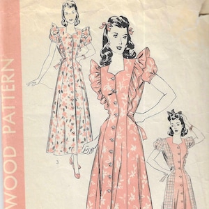 May include: Vintage Hollywood Pattern featuring three dress designs. The dresses are button-down, with floral and plaid patterns. The size 16 pattern includes bust and hip measurements. The image has a pink and white color scheme.