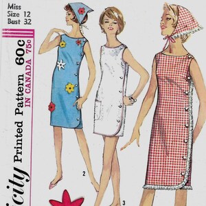 May include: A Simplicity sewing pattern envelope 5483 for a sleeveless dress in three variations. The illustration shows a blue dress with floral appliqués, a white dress with pockets, and a red and white gingham dress with button details.