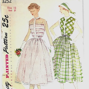May include: Vintage Simplicity printed pattern featuring two dress designs. One dress is a light pink with horizontal stripes on the bodice, and the other is a green plaid. The pattern includes the text "Size 13, Bust 31" and "25c".