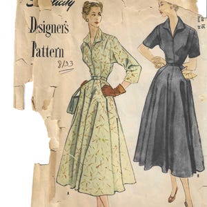 May include: Vintage Simplicity Designer's Pattern 8/33. The illustration shows two women in dresses. One dress is light green with a pattern, the other is dark gray. The pattern is printed on aged paper.