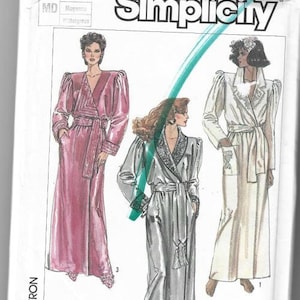May include: Simplicity sewing pattern number 7186 for a robe. The pattern includes three different styles of robes, one in pink, one in silver, and one in white. The pattern is for sizes Medium, Moyen, and Mittellgross.