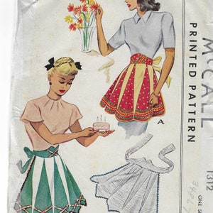 May include: Vintage McCall's sewing pattern for a Misses' Apron, pattern number 1312. The pattern includes three different styles of aprons: a red and yellow gingham apron, a green and white striped apron, and a white apron with a scalloped edge. The pattern is printed on a white background with black text.