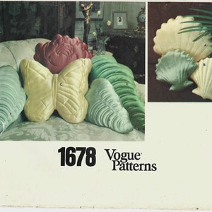May include: A vintage Vogue sewing pattern for pillows, featuring a butterfly, seashells, and leaf designs. The pattern number is 1678.