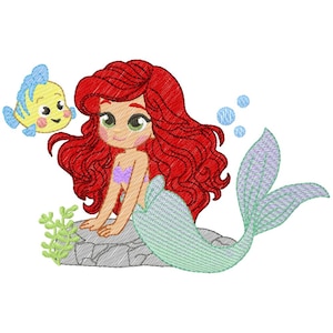 May include: An embroidered design of a mermaid with red hair, a purple top, and a light green tail, sitting on a rock. A yellow fish with blue accents swims nearby. Blue bubbles and green seaweed complete the design.