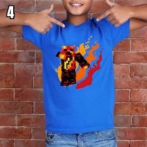 K&ouml;nnte beinhalten: Ein blaues T-Shirt mit einem pixeligen Charakterdesign und Flammen in Rot-, Orange- und Gelbt&ouml;nen. Die Figur ist schwarz und rot. Die Zahl 4 befindet sich in der oberen linken Ecke.