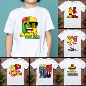 Puede incluir: Camisetas blancas con gráficos de dibujos animados coloridos. Una camiseta presenta un personaje de sandía sonriente con gafas de sol y el texto "SUNNY MELON". Otras camisetas muestran varios personajes de dibujos animados y frases como "SUNNY OPINION".