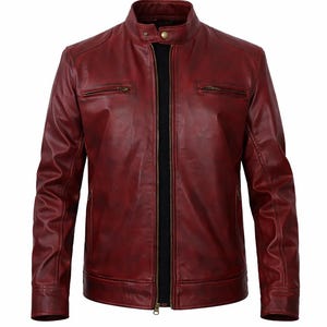 A burgundy leather jacket with a stand-up collar and a front zip. The jacket features two zipped chest pockets and a black inner lining. The long sleeves have a classic design.