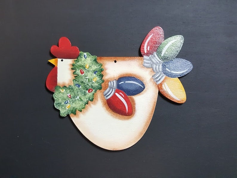 Chicken with wreath around neck, all feathers are Christmas light bulbs. Lights are bright red, blue, yellow and green.