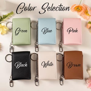 May include: A selection of keychains in various colors: green, blue, pink, black, white, and brown. Each keychain has a metal chain and ring. The words "Color Selection" are written at the top of the image.
