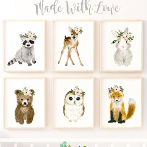 May include: Set of six watercolor animal prints featuring a raccoon, deer, rabbit, bear, owl, and fox. Each animal is wearing a floral crown. The prints are perfect for a nursery or child's room.