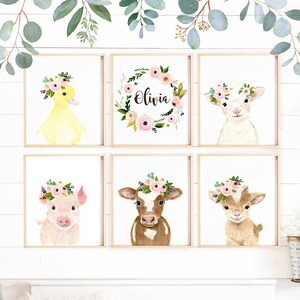 May include: Six watercolor animal prints with floral wreaths. The prints feature a duck, a lamb, a pig, a cow, a goat, and a floral wreath with the name Olivia. The prints are in a nursery setting with a crib and a blanket.
