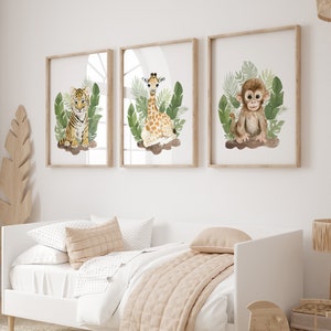May include: Three framed watercolor illustrations of jungle animals. A tiger cub sits in green leaves, a giraffe calf stands in green leaves, and a monkey sits in green leaves.