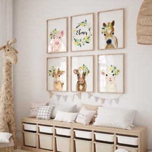 May include: A nursery room with a wooden storage bench with six drawers, a giraffe stuffed animal, a wooden stacking toy, and a set of six framed prints featuring watercolor illustrations of farm animals wearing flower crowns. The prints include a pig, a horse, a goat, a cow, a lamb, and a wreath with the name "Eleanor".