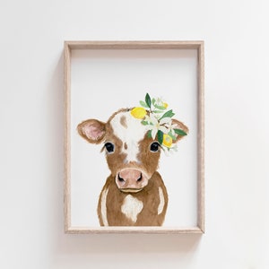 May include: A watercolor painting of a brown and white calf with a wreath of lemons and white flowers on its head.