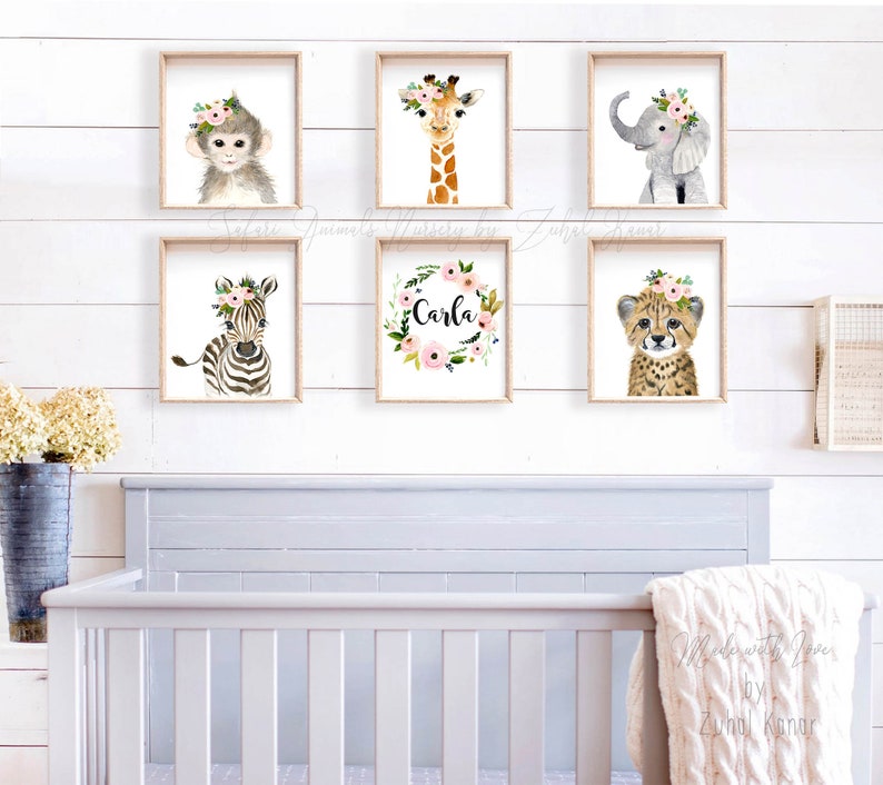 May include: A set of six nursery prints featuring watercolor illustrations of animals with floral crowns. The prints include a monkey, giraffe, elephant, zebra, cheetah, and a floral wreath with the name "Carla".