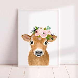 Puede incluir: Una pintura de acuarela de un ternero marr&oacute;n con una corona de flores rosas. El ternero est&aacute; mirando directamente al espectador con sus grandes ojos marrones. El fondo es blanco.