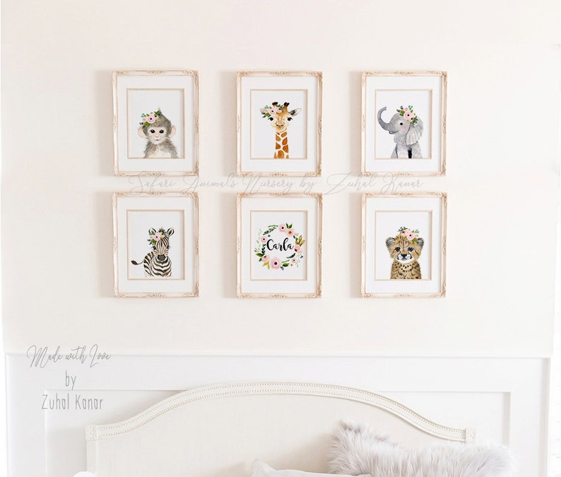 May include: Six framed prints of watercolor illustrations of safari animals with floral crowns. The animals include a monkey, giraffe, elephant, zebra, cheetah, and a floral wreath with the name "Carla".