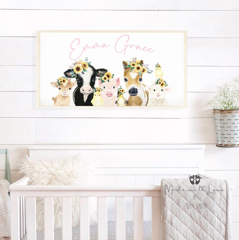 May include: A watercolor painting of farm animals with floral crowns. The animals include a cow, pig, horse, goat, and lamb. The painting is framed and has the name "Emma Grace" written in pink lettering at the top.