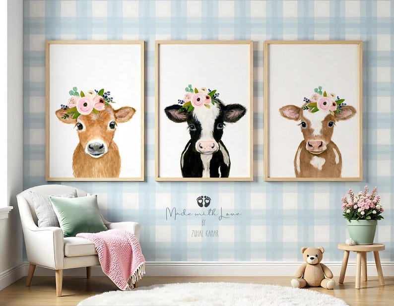Puede incluir: Tres acuarelas de vacas con coronas de flores. Las vacas son marrones y blancas, y las flores son rosas y verdes. Las pinturas est&aacute;n enmarcadas en madera y tienen un fondo blanco.