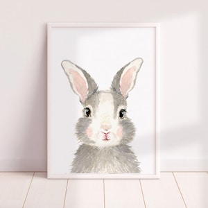May include: A watercolor painting of a gray and white rabbit with pink ears and nose. The rabbit is looking directly at the viewer.