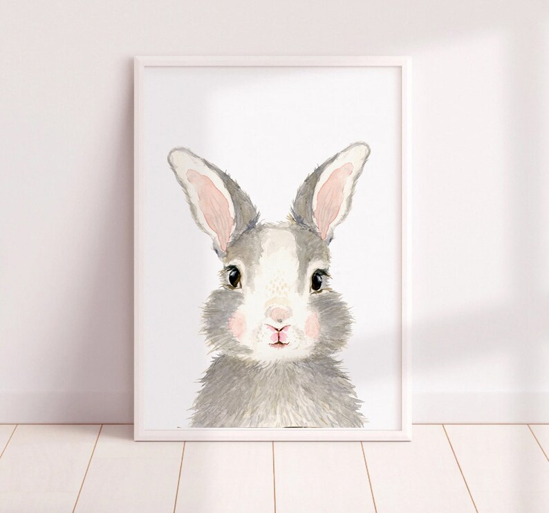 May include: A watercolor painting of a gray and white rabbit with pink ears and nose. The rabbit is looking directly at the viewer.