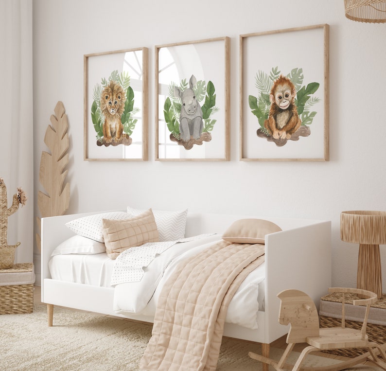 May include: Three framed watercolor illustrations of jungle animals. The illustrations feature a lion, a rhinoceros, and a monkey. Each animal is surrounded by green leaves.