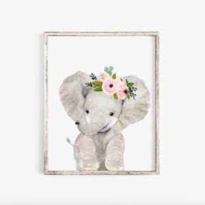 Pode incluir: Uma pintura em aquarela de um elefante cinza usando uma coroa floral rosa e verde. O elefante est&aacute; sentado com a tromba enroscada e os olhos fechados.