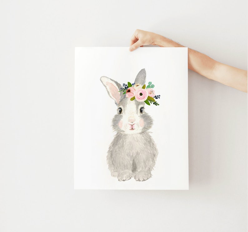 May include: A gray bunny with a pink and green flower crown. The bunny is sitting on a white background.