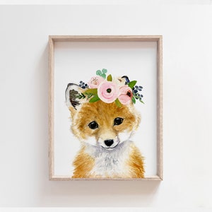 K&ouml;nnte beinhalten: Ein Aquarellbild eines Fuchses, der eine rosa und wei&szlig;e Blumenkrone tr&auml;gt. Der Fuchs hat ein hellbraunes Fell und eine wei&szlig;e Schnauze. Der Hintergrund ist wei&szlig;.