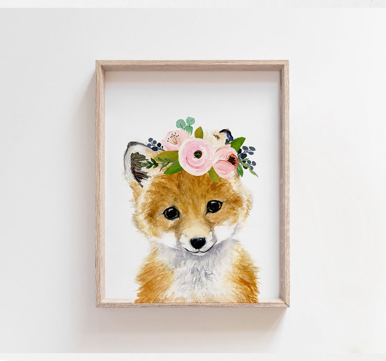 K&ouml;nnte beinhalten: Ein Aquarellbild eines Fuchses, der eine rosa und wei&szlig;e Blumenkrone tr&auml;gt. Der Fuchs hat ein hellbraunes Fell und eine wei&szlig;e Schnauze. Der Hintergrund ist wei&szlig;.