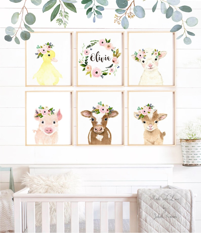 May include: Six watercolor animal prints with floral wreaths. The prints feature a duck, a lamb, a pig, a cow, a goat, and a floral wreath with the name Olivia. The prints are in a nursery setting with a crib and a blanket.