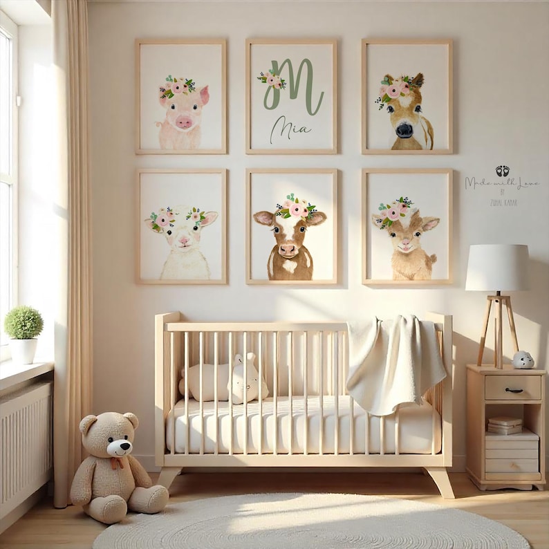 May include: A nursery room with a crib, a nightstand, a teddy bear, and six framed prints on the wall. The prints feature watercolor illustrations of farm animals wearing flower crowns. The prints include a pig, a cow, a lamb, and a goat. The name "Mia" is written on one of the prints.