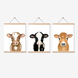 May include: Three framed watercolor paintings of calves. The first calf is brown and white, the second is black and white, and the third is brown. Each calf is looking directly at the viewer.