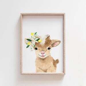 May include: A watercolor painting of a brown baby goat with a white face. The goat is wearing a crown of white flowers and yellow lemons.