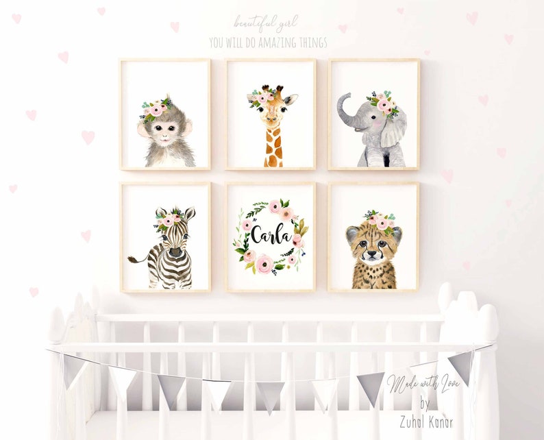 May include: A set of six nursery prints featuring watercolor illustrations of animals wearing floral crowns. The animals include a monkey, giraffe, elephant, zebra, cheetah, and a floral wreath with the name "Carla".