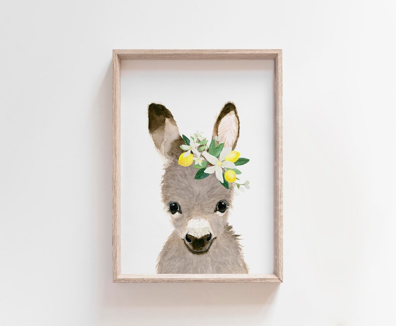 May include: A watercolor painting of a gray donkey wearing a flower crown with white flowers and yellow lemons. The donkey is looking directly at the viewer with a sweet expression.