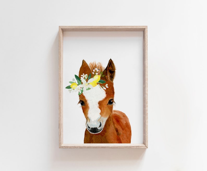 May include: A watercolor painting of a brown and white foal wearing a flower crown with yellow lemons. The foal is looking directly at the viewer.