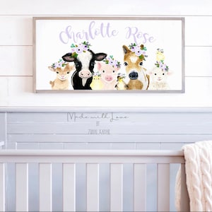 May include: A white framed print with a watercolor illustration of a cow, pig, horse, goat, and chick wearing flower crowns. The print says "Charlotte Rose" in purple text and "Made with Love by Zurial Kanar" in black text.