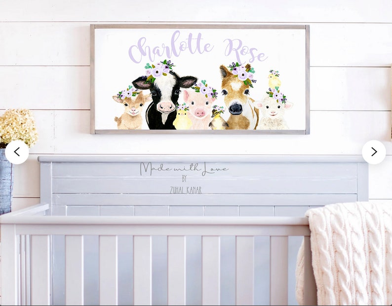 May include: A white framed print with a watercolor illustration of a cow, pig, horse, goat, and chick wearing flower crowns. The print says "Charlotte Rose" in purple text and "Made with Love by Zurial Kanar" in black text.