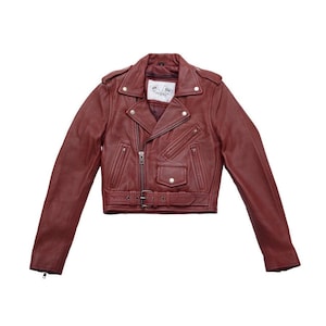 Puede incluir: Chaqueta de cuero burdeos estilo motero con cierre de cremallera asim&eacute;trico, solapas de muesca y cintur&oacute;n en la cintura. La chaqueta tiene m&uacute;ltiples bolsillos con cremallera y charreteras. El dise&ntilde;o corto y el color intenso le dan un aspecto elegante y atrevido.