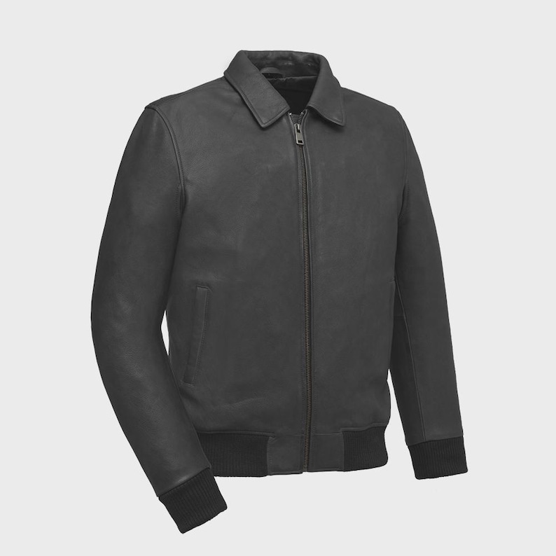 May include: A dark gray leather jacket with a collared neckline and a full-length zipper. The jacket features a ribbed knit hem and cuffs. The jacket has a classic bomber style.