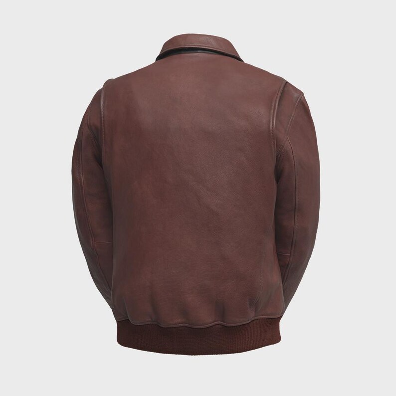 May include: A brown leather bomber jacket with a ribbed hem and cuffs. The jacket has a classic collar and a smooth, matte finish. The back view showcases the jacket's tailored fit and design.