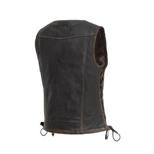 Pu&ograve; includere: Un gilet in pelle marrone dal design classico. Il gilet ha uno scollo a V, un lato allacciato e un bordo marrone. Il retro del gilet &egrave; visibile, mostrando le cuciture e la forma generale. Il gilet &egrave; realizzato in pelle invecchiata.