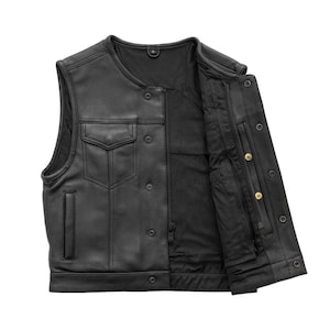 May include: Black leather vest with a snap-button closure and two front pockets. The vest has a zippered interior pocket and a mesh lining. The vest is sleeveless and has a round neckline. The vest is open, revealing the interior lining.