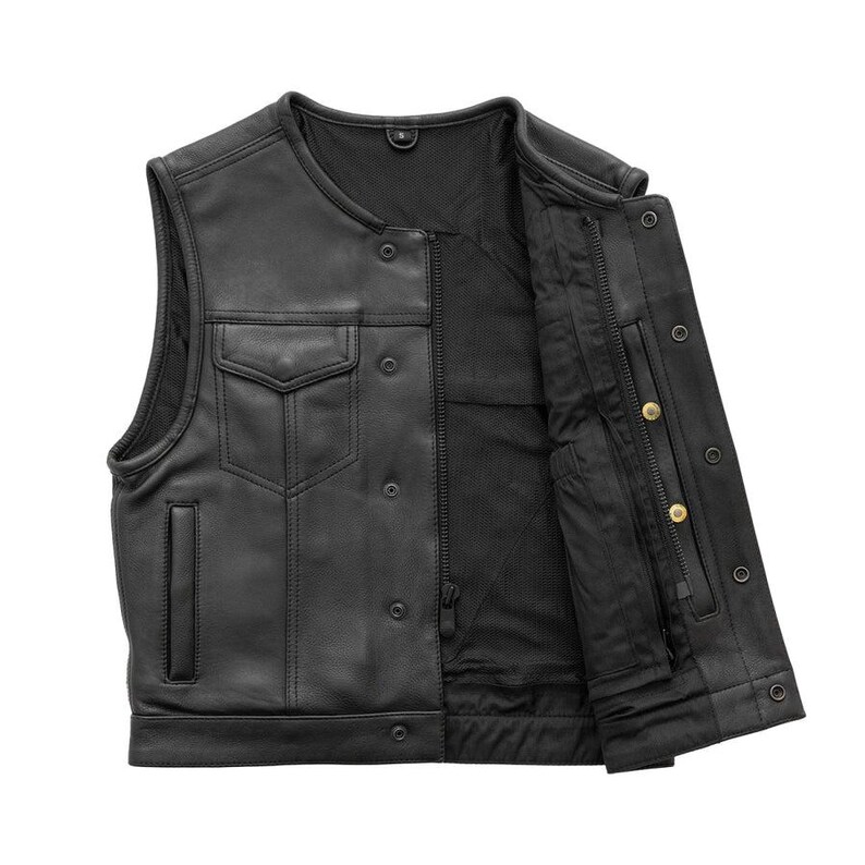 May include: Black leather vest with a snap-button closure and two front pockets. The vest has a zippered interior pocket and a mesh lining. The vest is sleeveless and has a round neckline. The vest is open, revealing the interior lining.