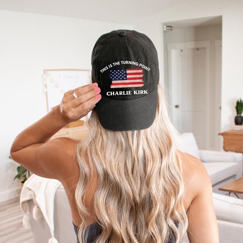 May include: Black baseball cap with the text "THIS IS THE TURNING POINT" and "CHARLIE KIRK" printed on the front. The cap features a distressed American flag design in red, white, and blue.