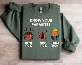 May include: An olive green sweatshirt featuring the text "KNOW YOUR PARASITES" above illustrations of a deer tick, dog tick, and a cartoon of a person. The text "DEER TICK", "DOG TICK", and "LUNA TICK" are below the illustrations.