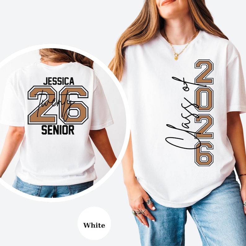 Puede incluir: Camiseta blanca con "Class of 2026" en letras marrones y negras en la parte delantera. La parte trasera de la camiseta presenta el nombre "Jessica", el n&uacute;mero "26" y la palabra "SENIOR" en una combinaci&oacute;n de colores similar.