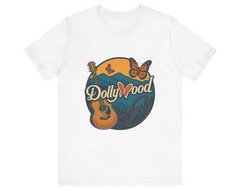May include: White t-shirt featuring a circular graphic with the text "Dollywood". The graphic includes a guitar, butterflies, and a roller coaster against a mountain backdrop. The design is in shades of orange, blue, and brown.