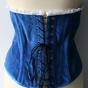 May include: A blue velvet corset with a white lace trim and black lacing in the back.